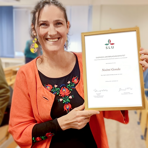Noémi Gonda displaying her diploma.