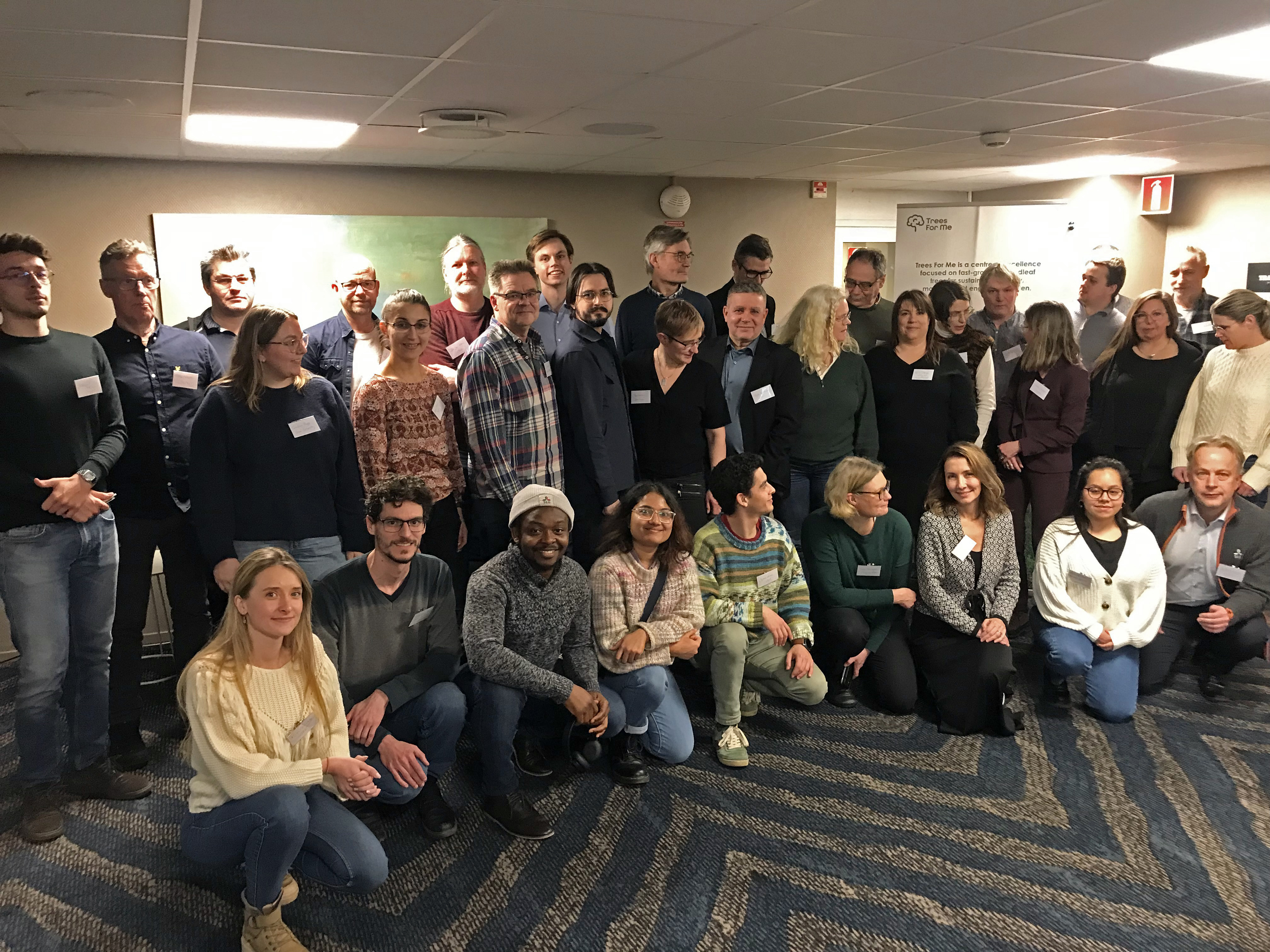 Group image of people in conference room. Photo.