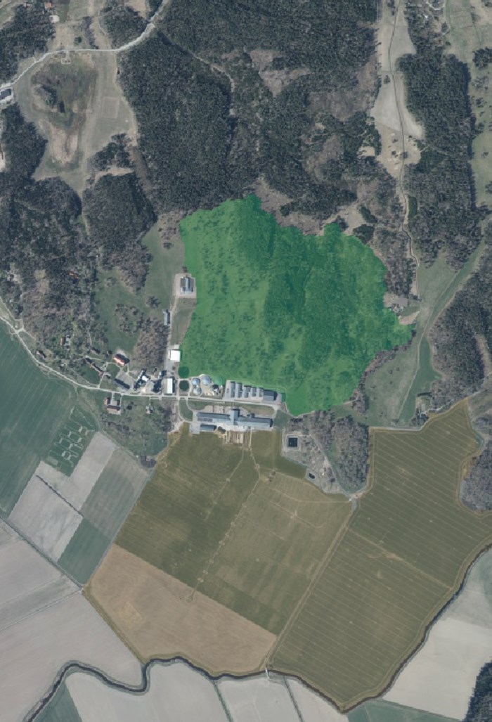Flygfoto över Lövsta forskningscentrum. En grönmarkerad yta visar naturbete och en brun yta visar åkermark.