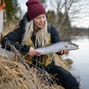 Linda håller en havsöring. Foto.