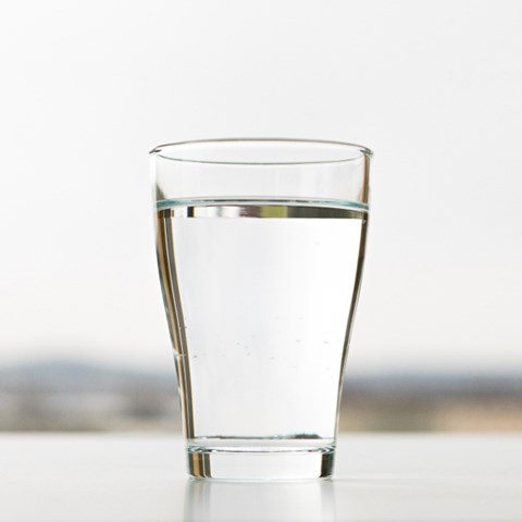 Ett glas med vatten. Foto. 