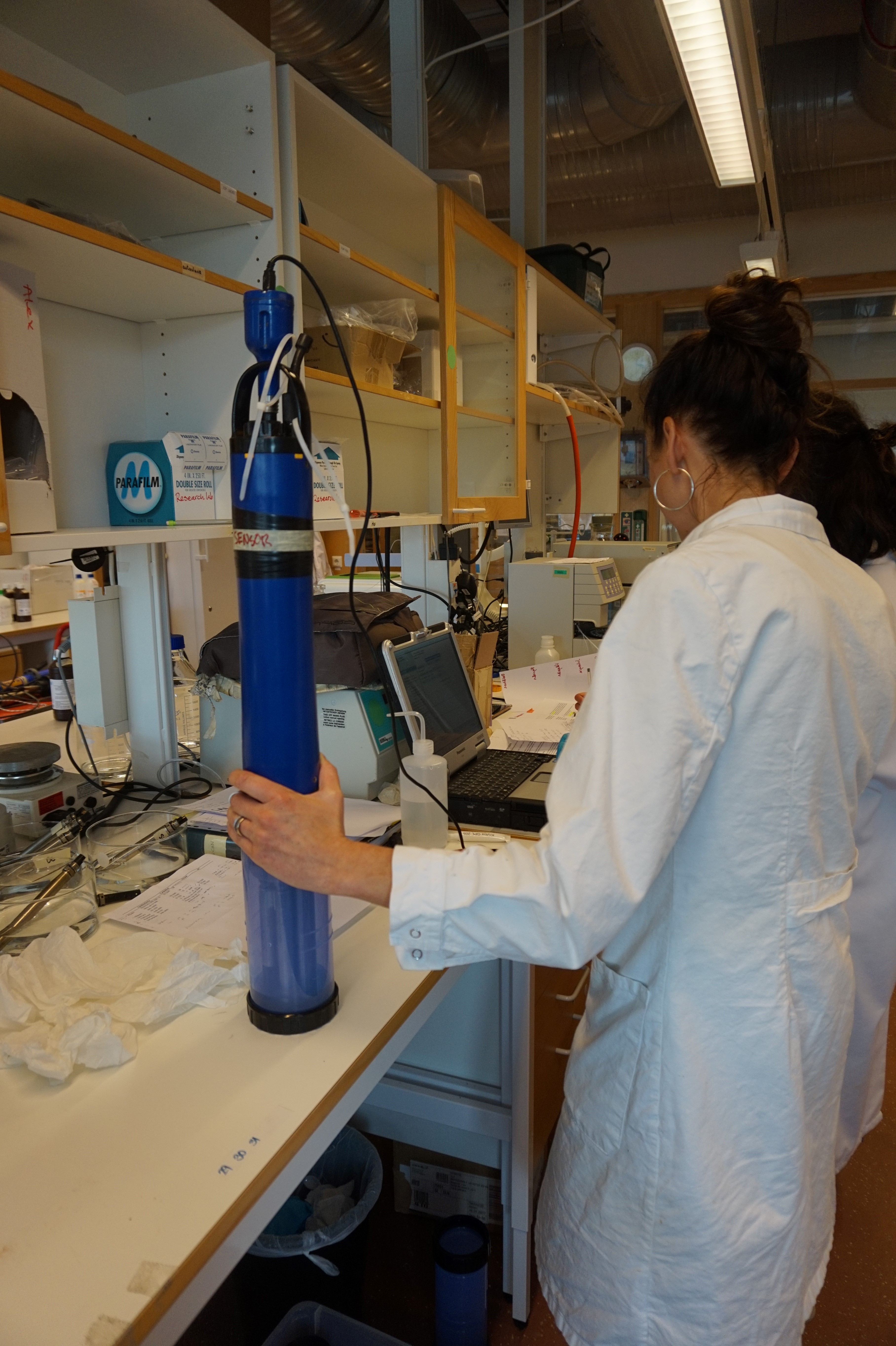 Kvinna på laboratorium som håller i en sond. Foto.