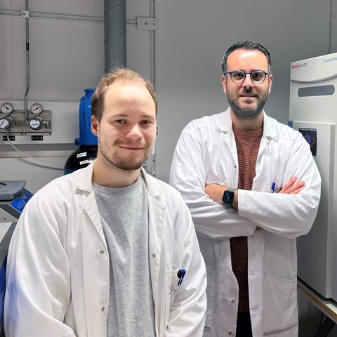 Svante och Alberti står i labbet i vita labbrockar. Foto.