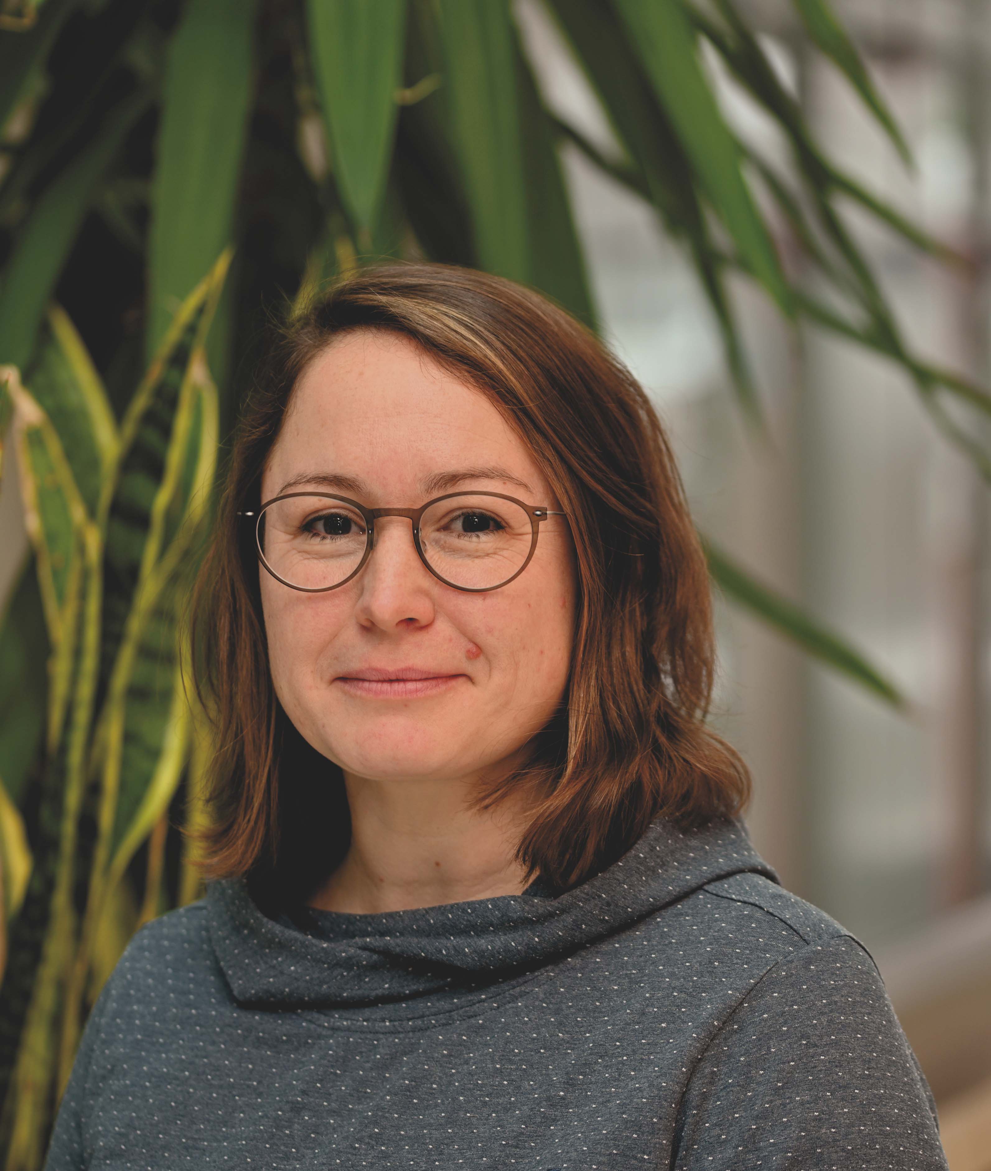 Kvinna i grå tröja och glasögon.