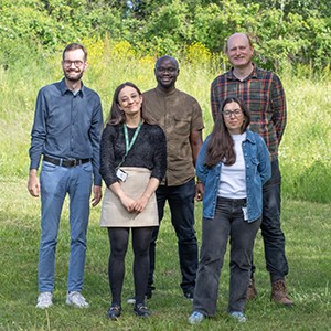Five people standing outside looking at the photographer.