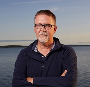 Man framför ett hav. Foto