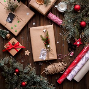 Packages, strings, wrapping paper and tree branches with Christmas decorations. Photo.