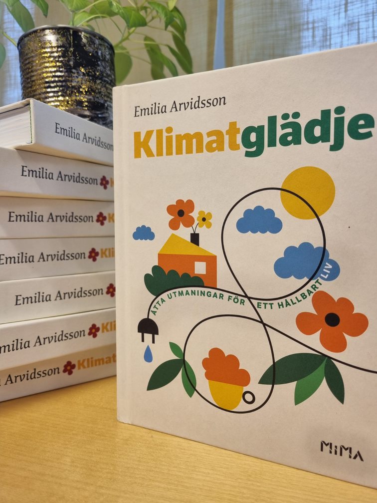 Boken Klimatglädje ligger i en hög och bredvid visas omslaget. 