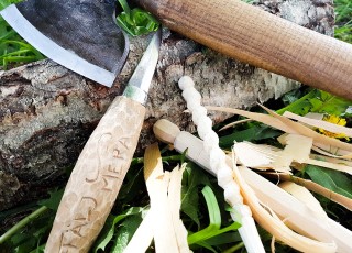 An axe and carving knife with some small pieces of wood, photograph.