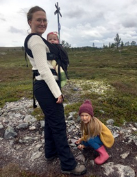 A woman in the mountains with two small children. Photo. 