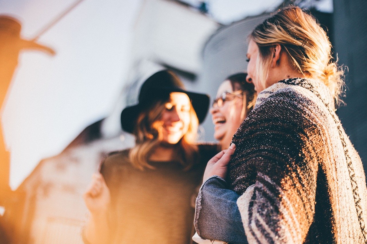Three women are talking and laughing. Photo.