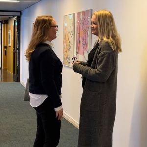 Två kvinnor står i en korridor och samtalar