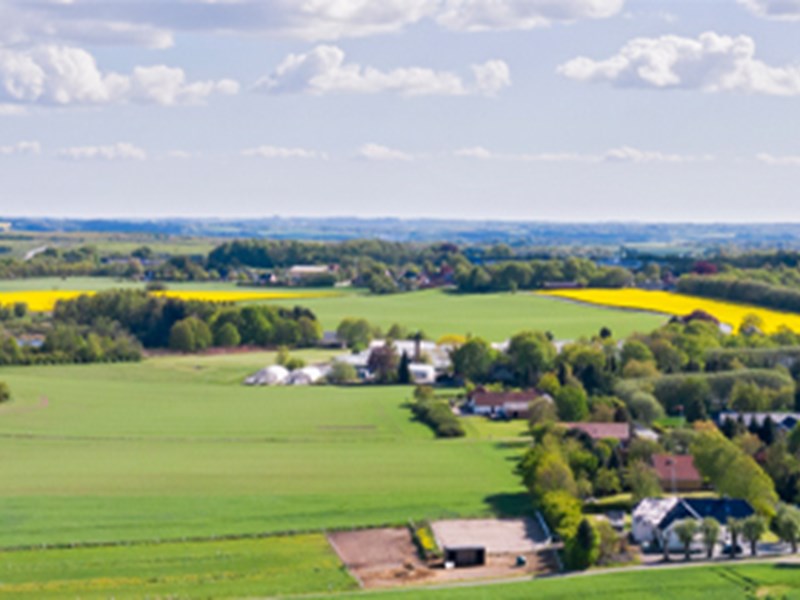 The picture shows a rural part of Sweden with a small village surrounded by fields and forests.