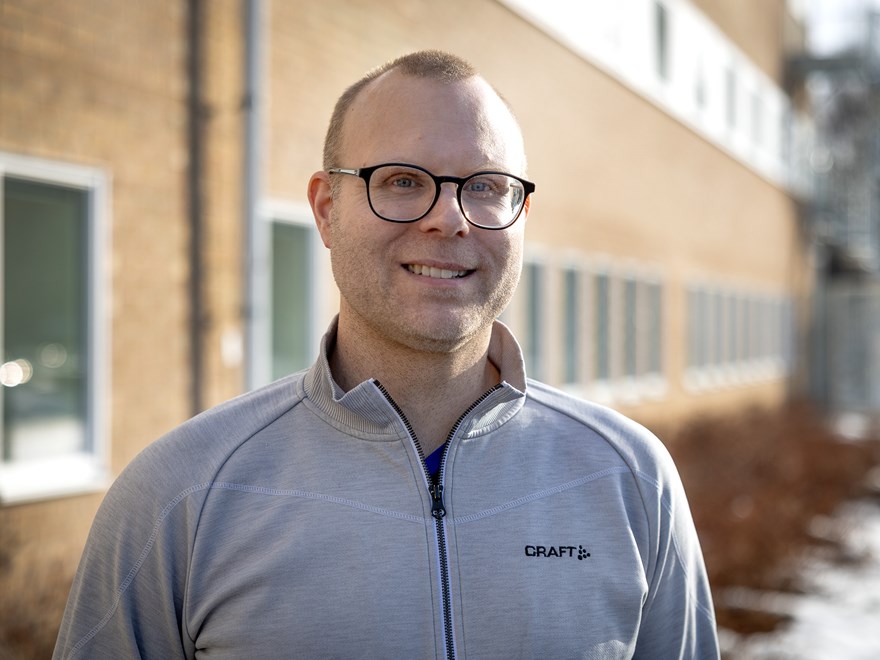 En man i grå tröja. Har glasögon