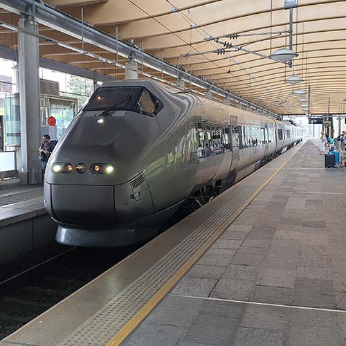 Ett modernt tåg står inne vid perrongen, foto.