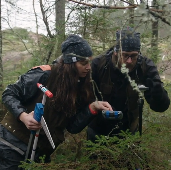 Två personer inventerar skog. Foto.