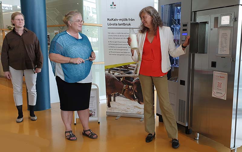 Vice Chancellor shows the bottle of milk she just bought from the milk vending machine and shows Sigrid Agenäs, photo.