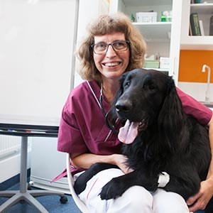 Veterinarian Helene Hamlin with a black dog, photo.