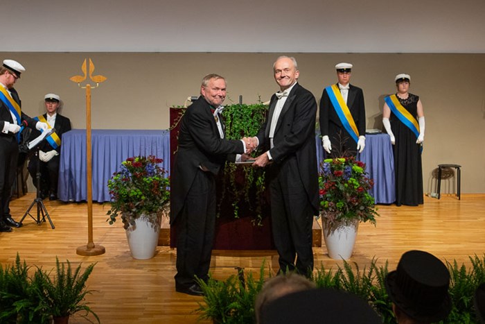 Picture of Jan Stenlid and Joakim Stymne shaking hands during the doctoral award ceremoni.