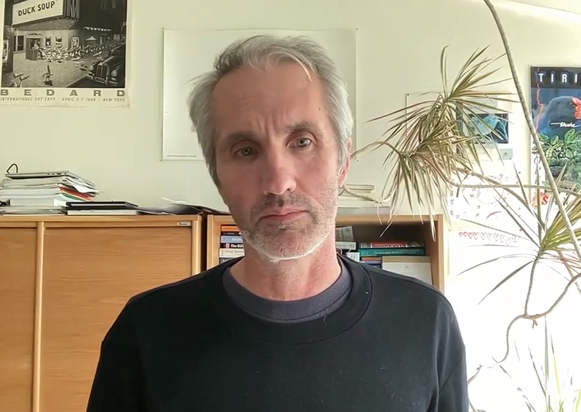 Bild på en man i ett rum med bokhyllor