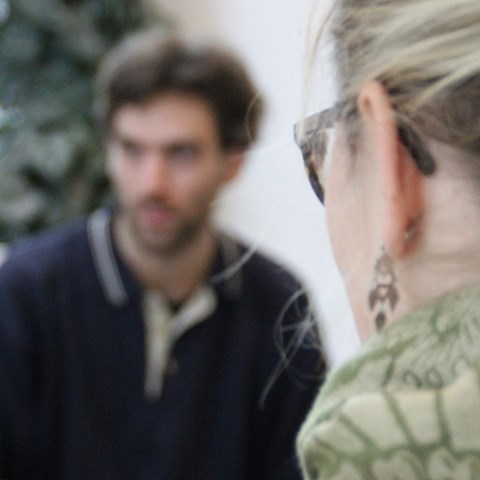 Two people sitting opposite each other and talking, photo.