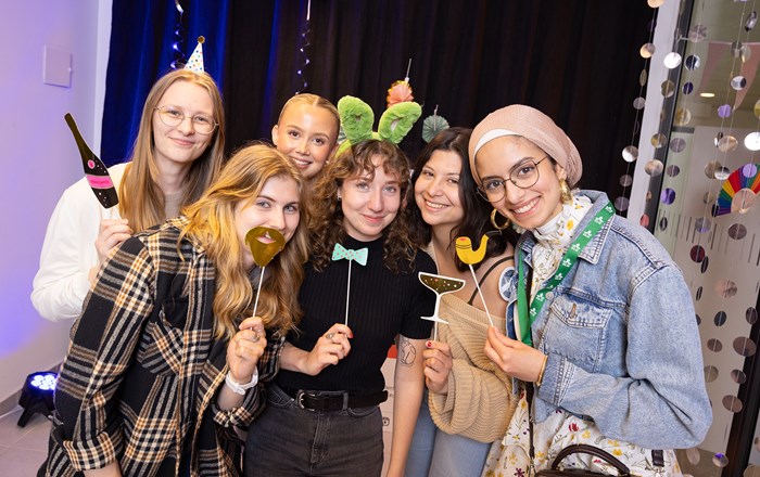 Students celebrating in the photo booth taking funny photos.